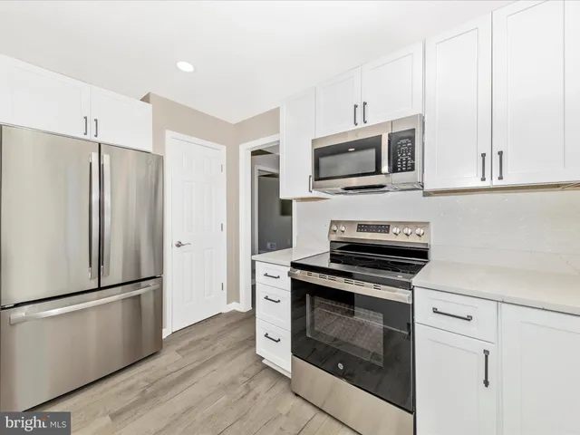 a kitchen with granite countertop a stove microwave and refrigerator