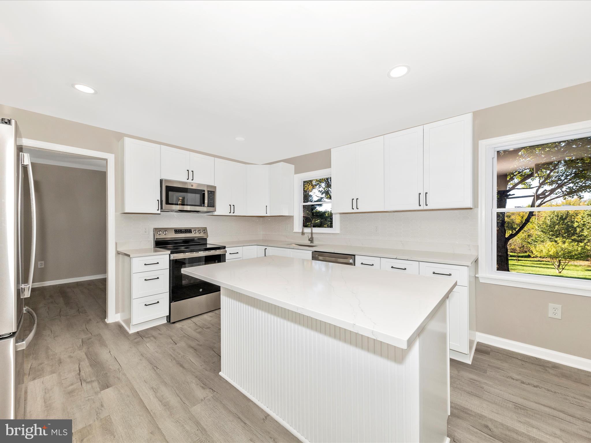 2431 Quebec School Road Middletown, MD 21769 - Photo 18 of 56 a kitchen with stainless steel appliances a stove a sink dishwasher a refrigerator with white cabinets and wooden floor