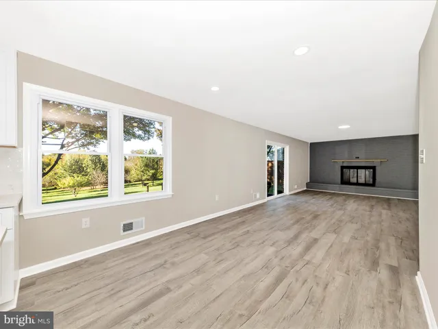a view of empty room with wooden floor and windows