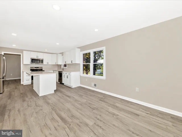 a kitchen with a refrigerator and a stove top oven
