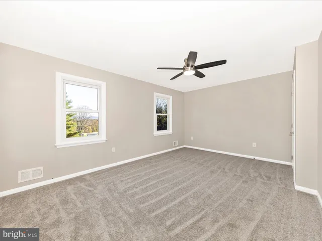 a view of a livingroom with a ceiling fan and window