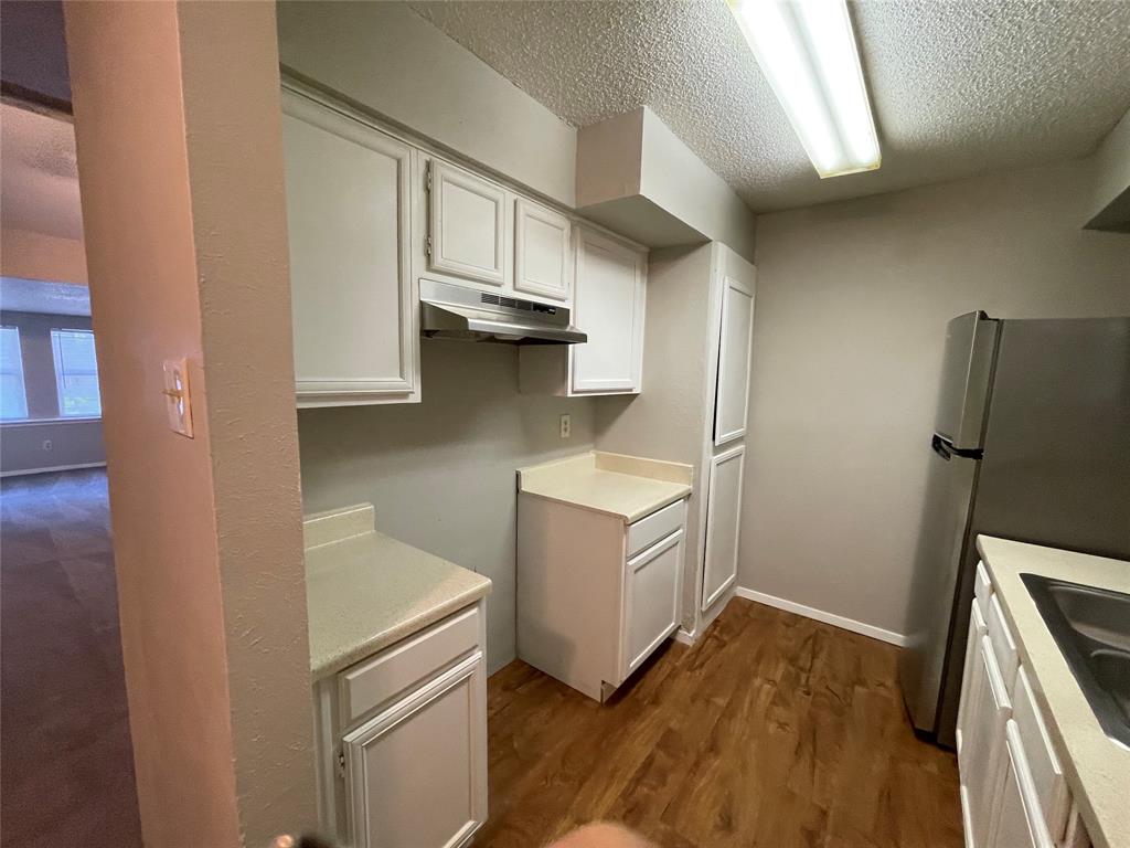 9696 Walnut Street, Unit 1413 Dallas, TX 75243 - Photo 12 of 17 a kitchen with cabinets and wooden floor