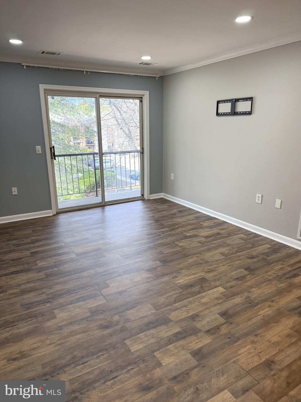 18324 Streamside Drive, Unit 301 Gaithersburg, MD 20879 - Photo 5 of 19 a view of an empty room with wooden floor and a window