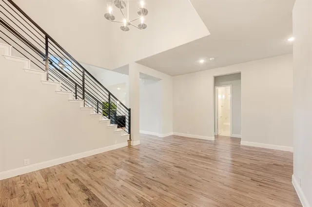 a view of an empty room with wooden floor and entryway