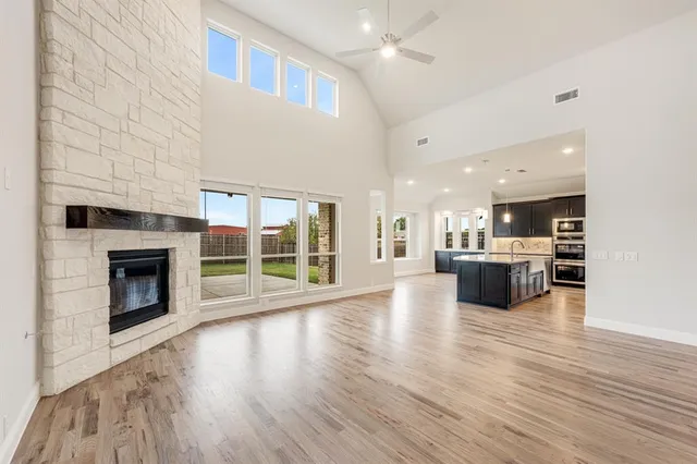 a view of kitchen with microwave a stove and wooden floor