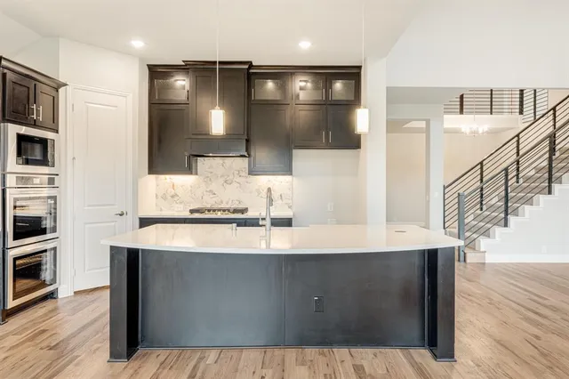 a kitchen with kitchen island a sink stainless steel appliances and cabinets