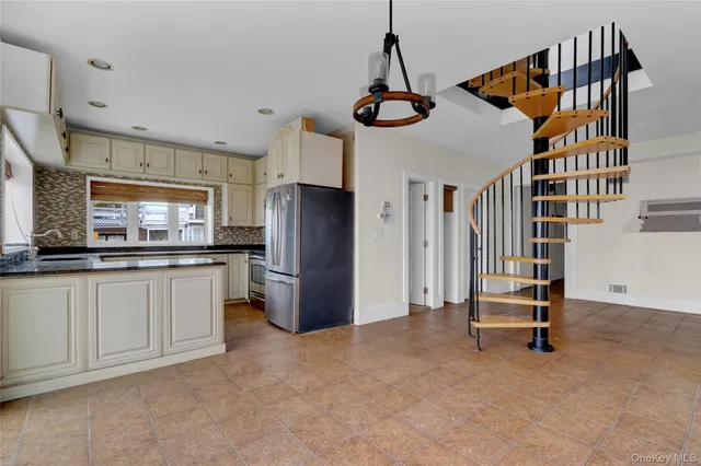a kitchen with stainless steel appliances granite countertop a stove a sink and a refrigerator