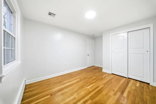 a view of empty room with wooden floor