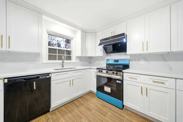 a large kitchen with stainless steel appliances granite countertop a refrigerator a sink dishwasher a stove top oven and a refrigerator