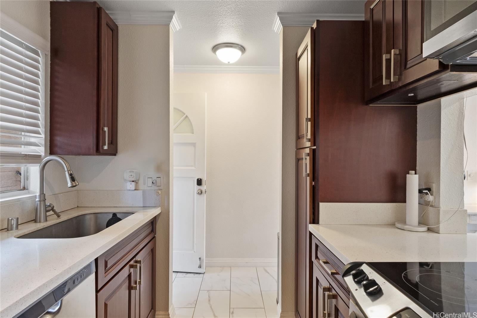 92-1232 Palahia Street, Unit AA102 Kapolei, HI 96707 - Photo 11 of 25 a kitchen with a sink cabinets and a refrigerator