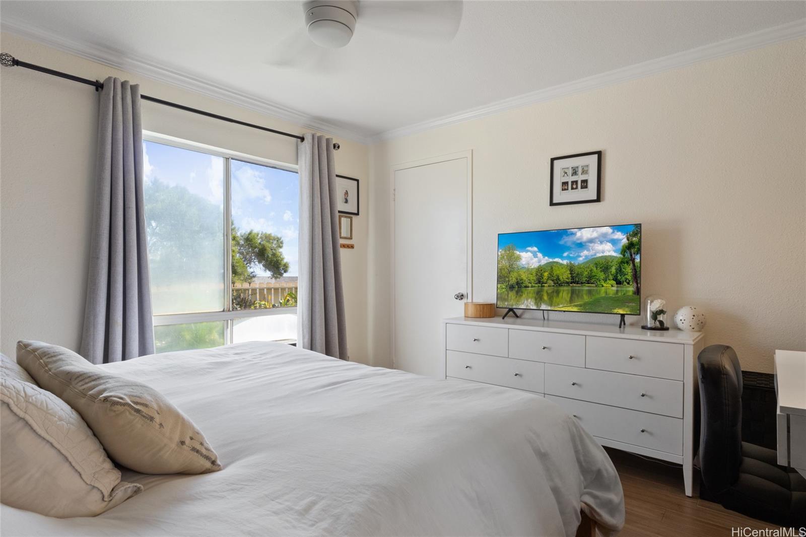 92-1232 Palahia Street, Unit AA102 Kapolei, HI 96707 - Photo 12 of 25 a bedroom with a bed and a flat screen tv