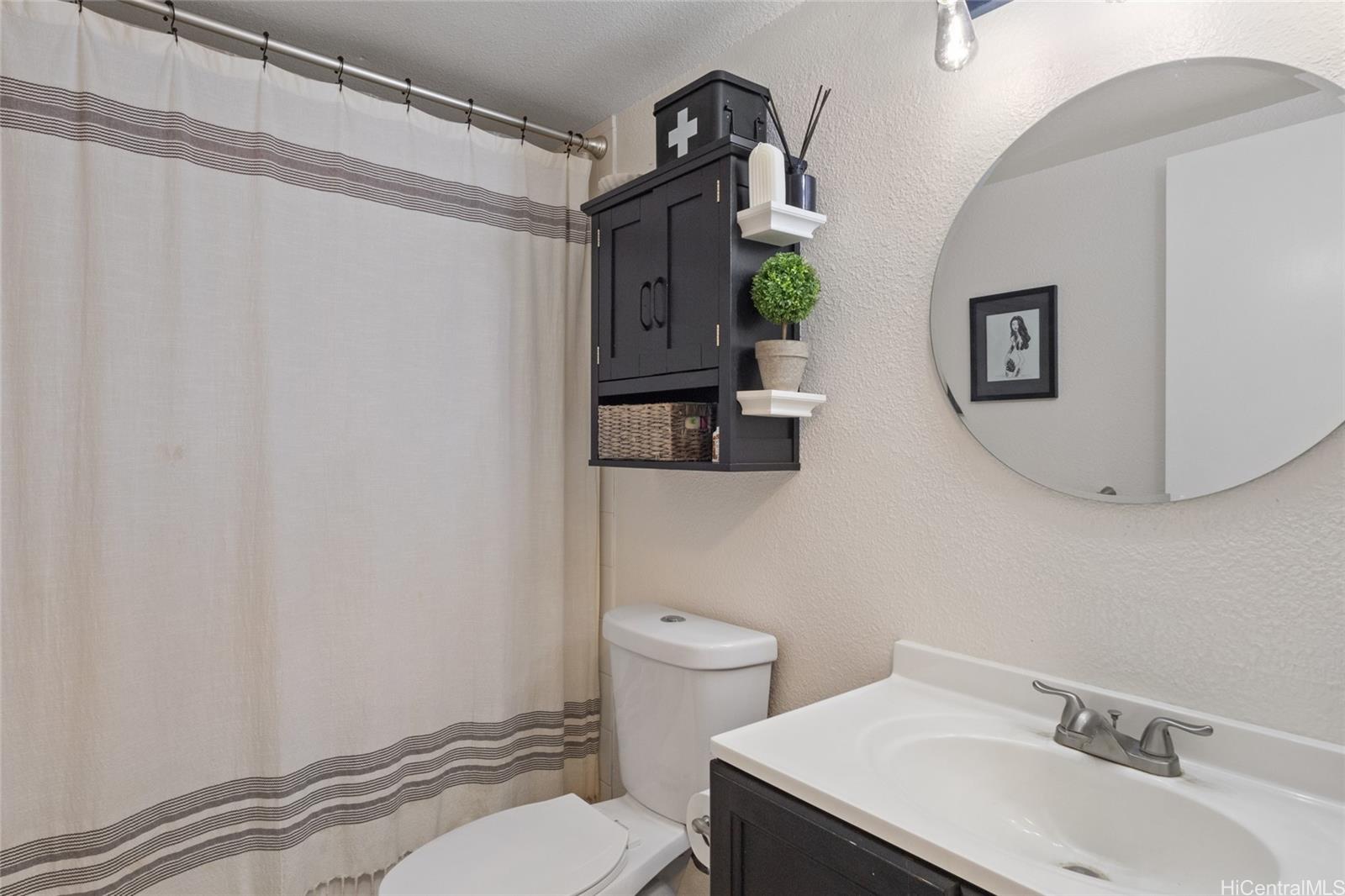92-1232 Palahia Street, Unit AA102 Kapolei, HI 96707 - Photo 16 of 25 a bathroom with a sink mirror vanity and toilet
