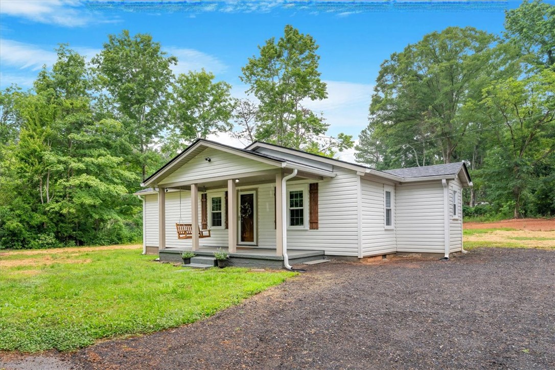 174 Holliday Road Six Mile, SC 29682 - Photo 2 of 49 A charming single-story residence with a welcoming front porch and swing, nestled among mature trees