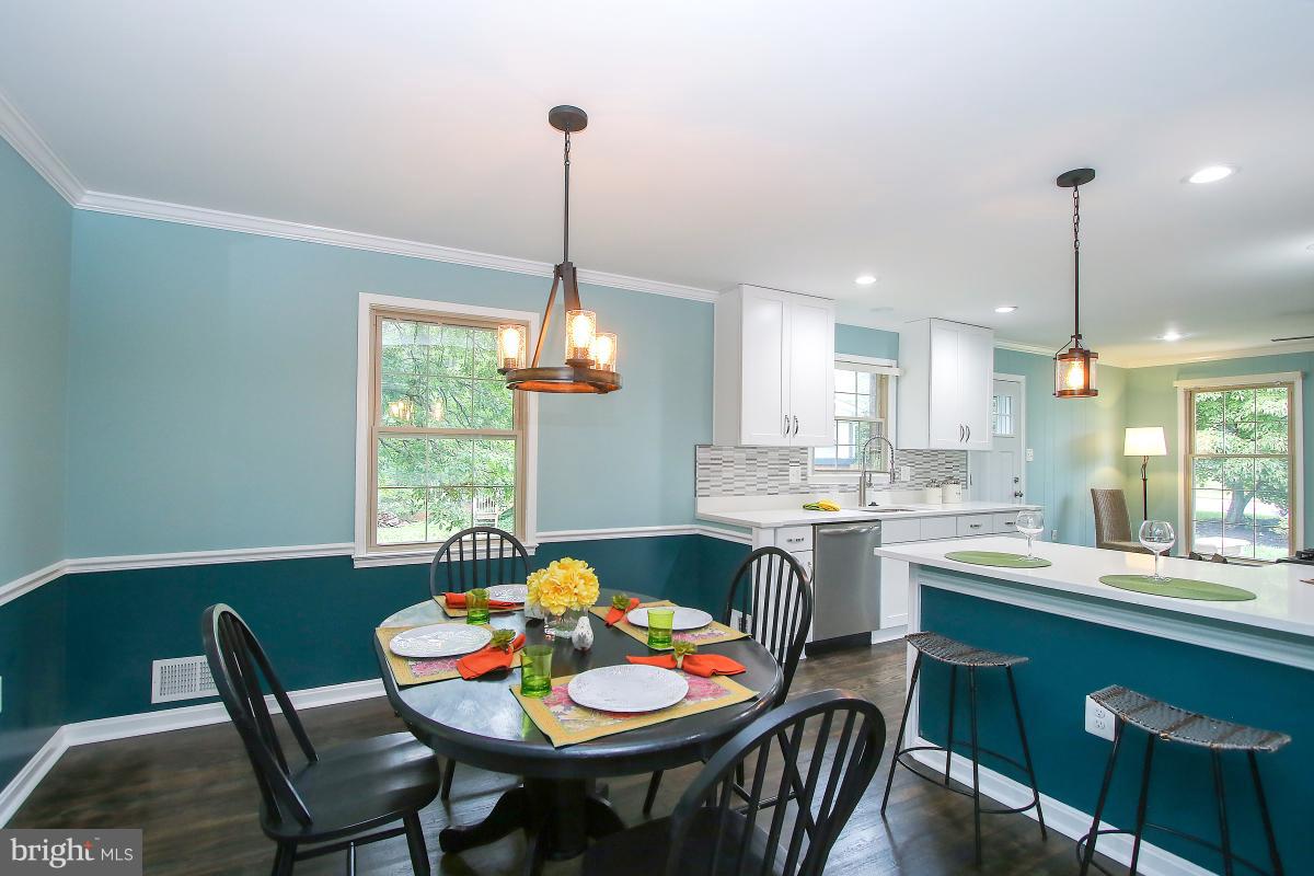 13121 Tamarack Road Silver Spring, MD 20904 - Photo 16 of 30 a kitchen with a dining table chairs and white cabinets