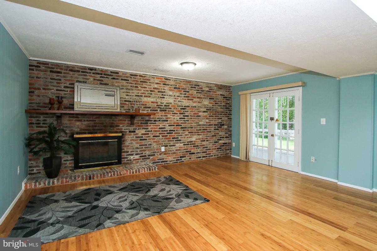 13121 Tamarack Road Silver Spring, MD 20904 - Photo 25 of 30 a living room with stainless steel appliances wooden floor and fireplace