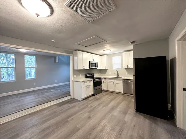 a kitchen with a refrigerator and a stove top oven