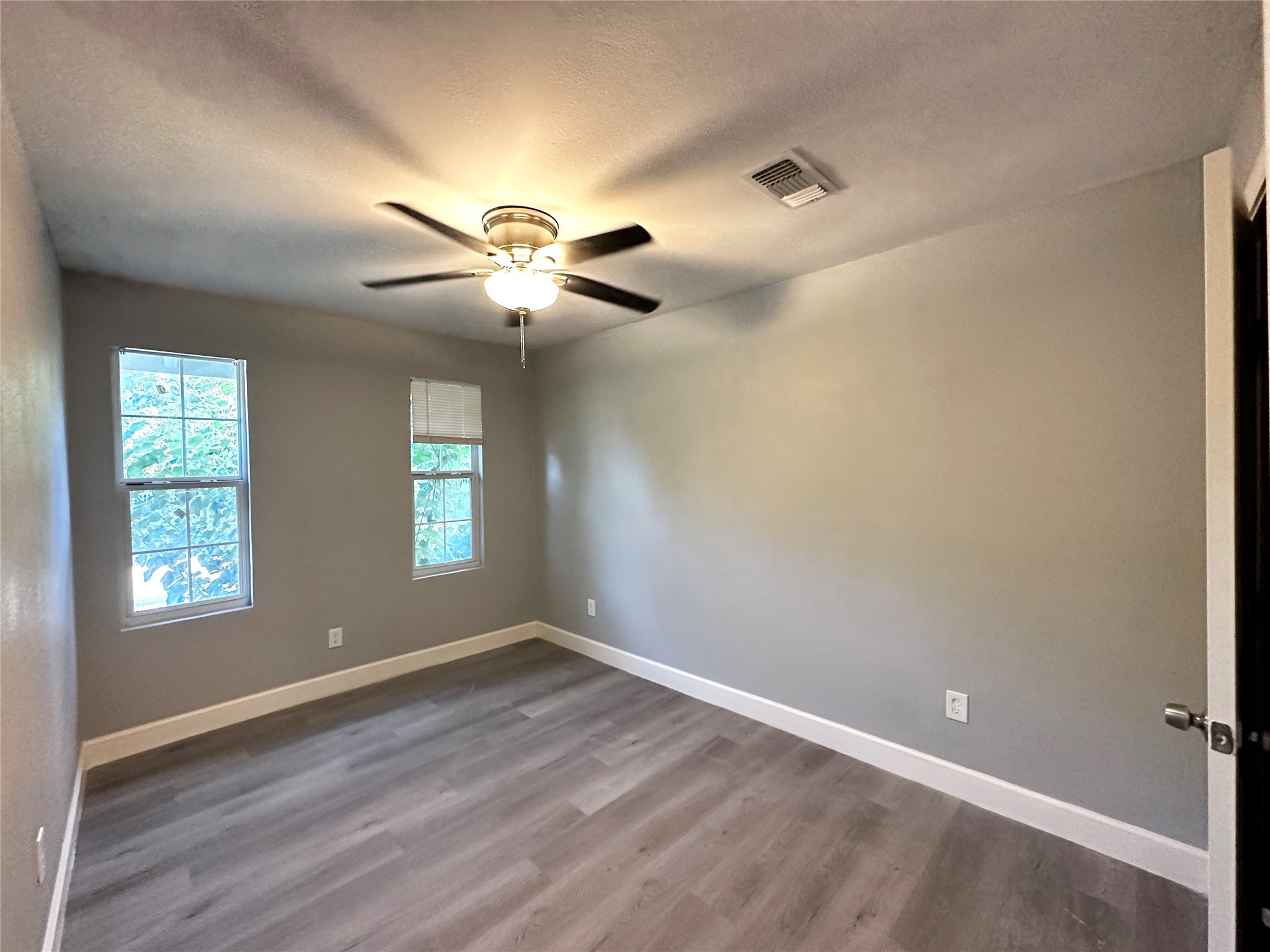 4318 1st Street, Unit B Bacliff, TX 77518 - Photo 9 of 21 wooden floor in an empty room with a window