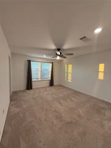a view of empty room with windows and ceiling fan