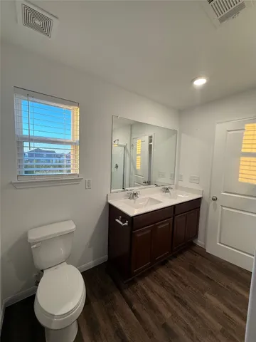 a bathroom with a granite countertop toilet sink and mirror