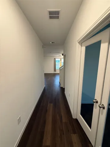 a view of a hallway with wooden floor
