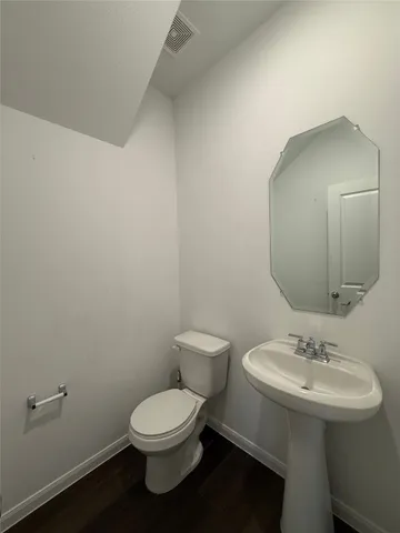 a bathroom with a toilet a sink and mirror