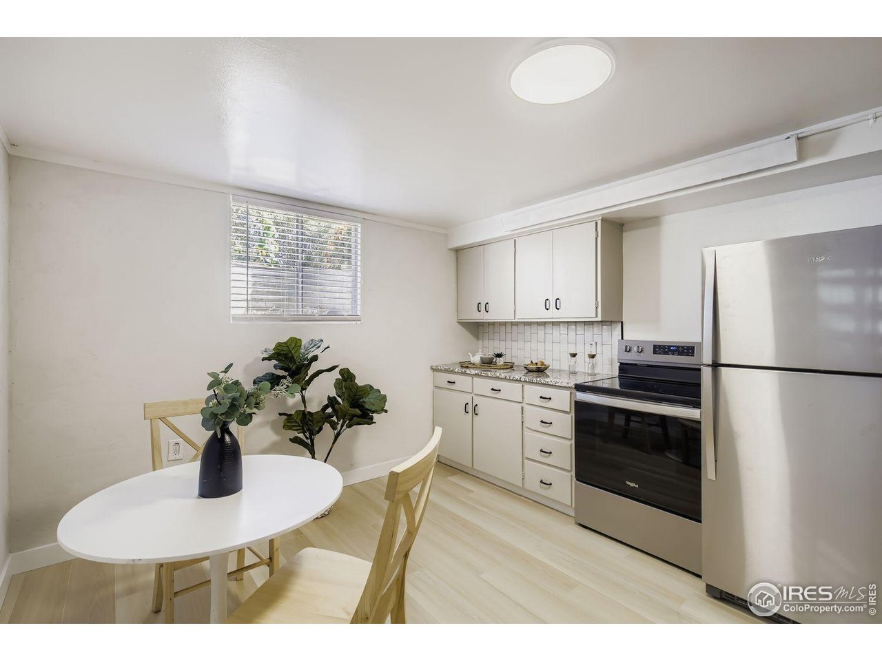 604 Colorado Street Fort Collins, CO 80524 - Photo 24 of 32 a kitchen with stainless steel appliances granite countertop a sink a stove a chimney a refrigerator and a window