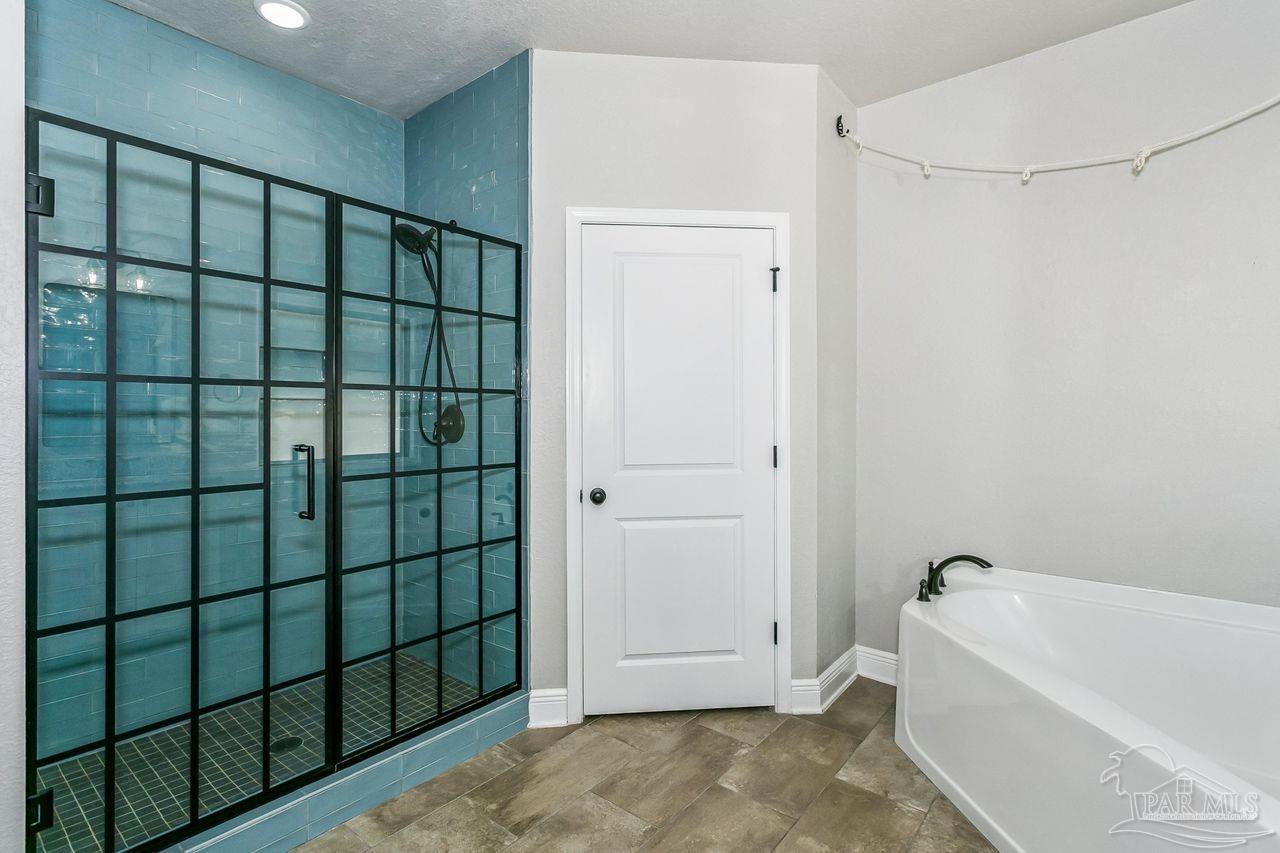3875 Shady Grove Drive Pace, FL 32571 - Photo 19 of 31 a bathroom with a bathtub and shower