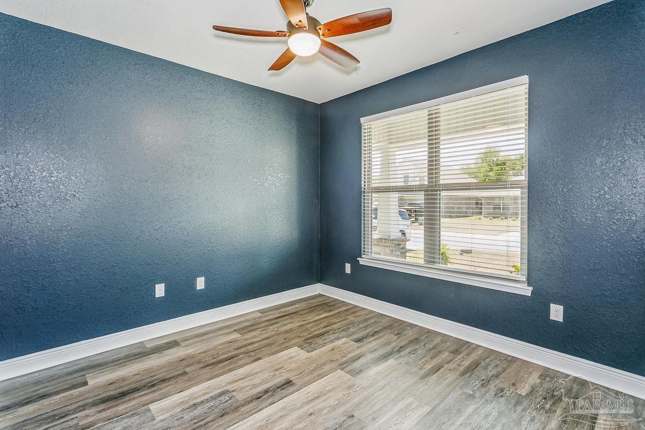 3875 Shady Grove Drive Pace, FL 32571 - Photo 20 of 31 a view of empty room with wooden floor and fan