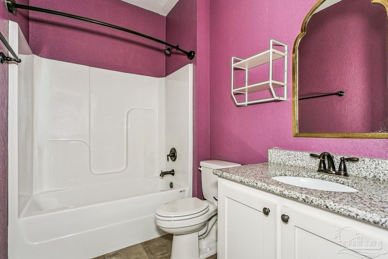 3875 Shady Grove Drive Pace, FL 32571 - Photo 23 of 31 a bathroom with a granite countertop sink toilet and shower