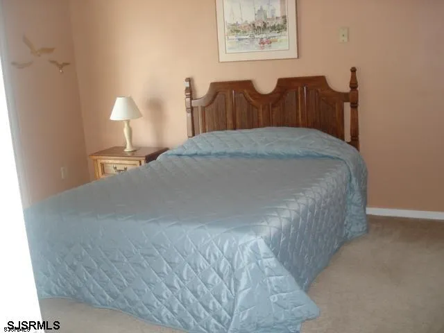 a bed sitting in a bedroom with painting on the wall