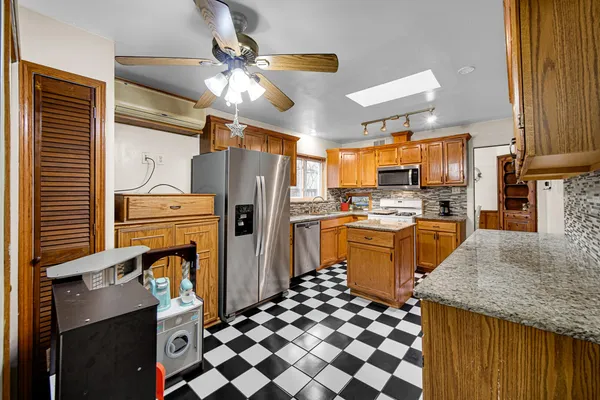 a kitchen with granite countertop appliances a sink and a refrigerator