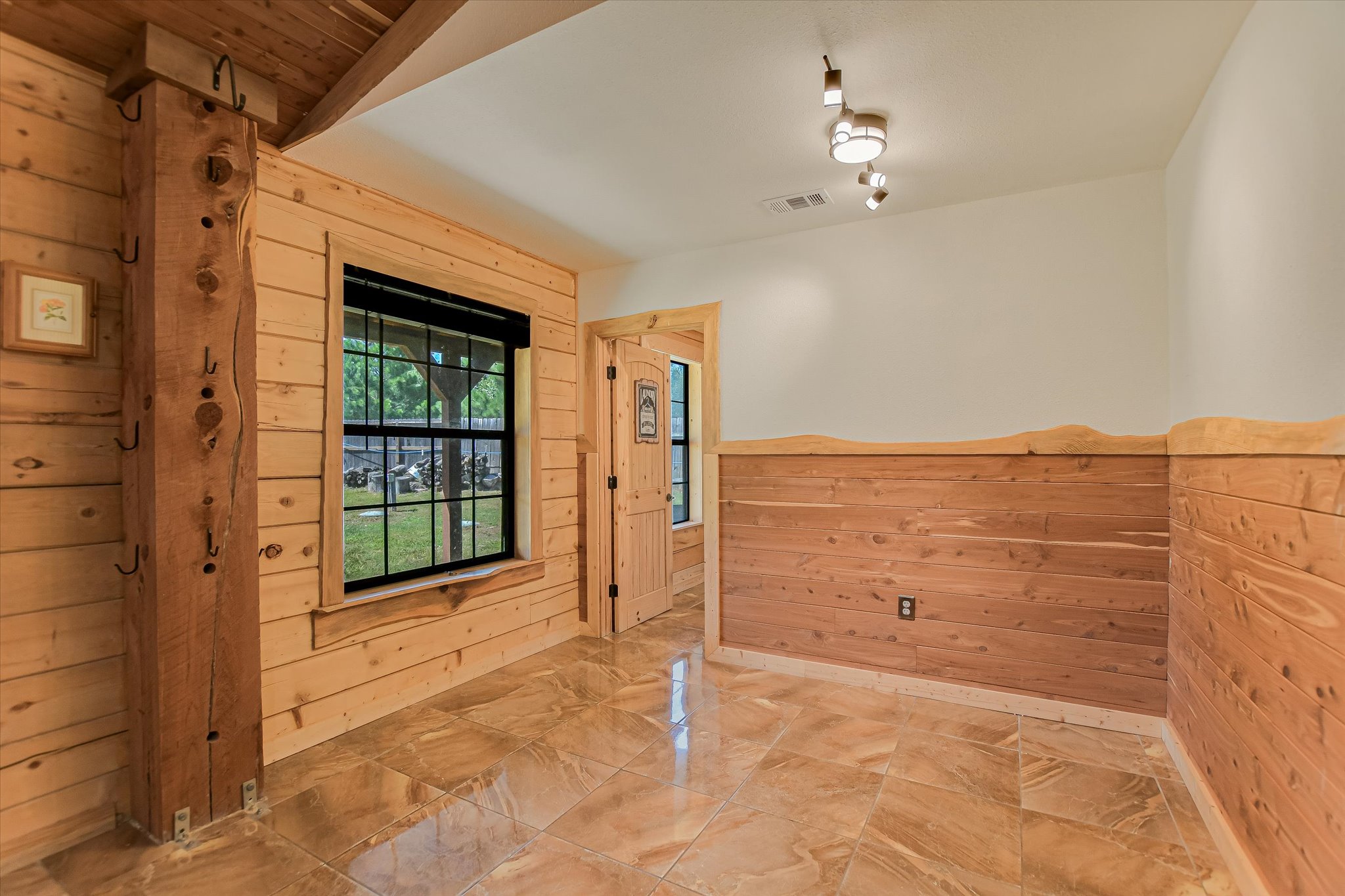 218 Cardinal Loop Paige, TX 78659 - Photo 9 of 22 Natural wood paneling adorns this versatile room, featuring lustrous tile flooring and abundant light.