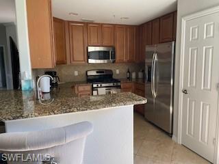 3149 Aviamar Circle, Unit 101 Naples, FL 34114 - Photo 5 of 20 a kitchen with stainless steel appliances granite countertop a refrigerator a stove a sink and a counter space