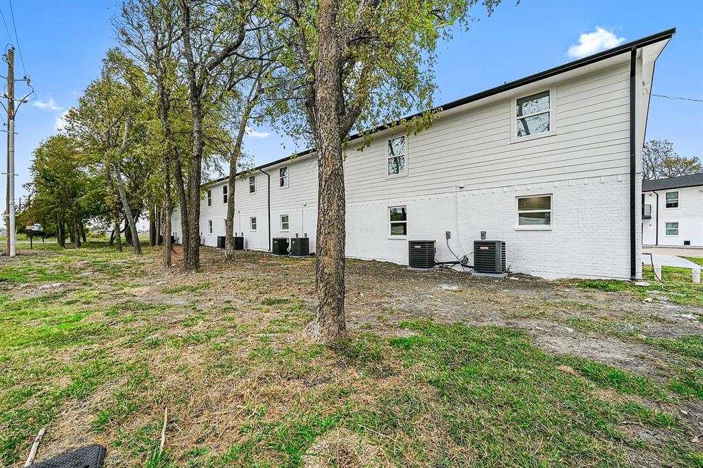 500 Highway 75, Unit 35 Van Alstyne, TX 75495 - Photo 12 of 12 Rear exterior featuring white painted brick and siding, multiple windows, and exterior HVAC units