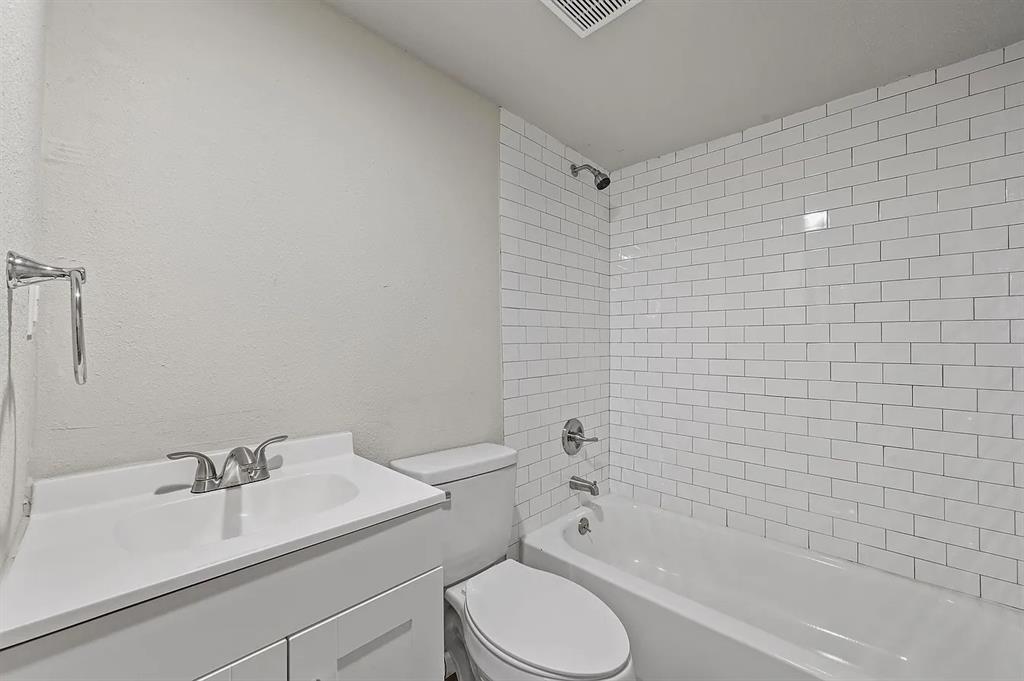 500 Highway 75, Unit 35 Van Alstyne, TX 75495 - Photo 7 of 12 Full bathroom featuring a white subway tile shower surround, chrome shower fixtures, a white vanity with an integrated sink, and a chrome faucet