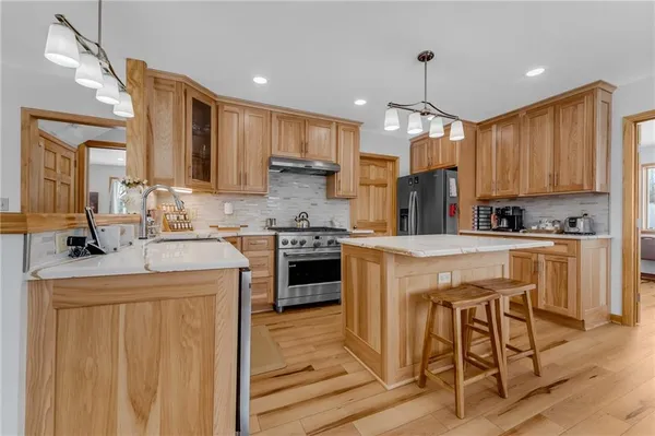 a kitchen with kitchen island granite countertop wooden cabinets and a refrigerator