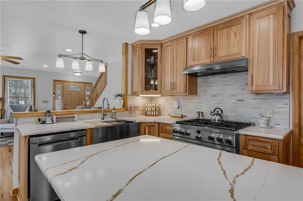 a kitchen with a stove a sink a refrigerator and wooden cabinets
