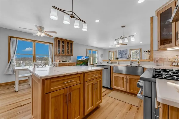 a kitchen with kitchen island granite countertop a sink cabinets and stainless steel appliances