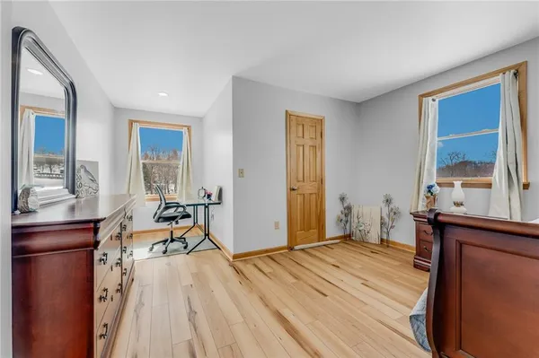 a bedroom with a bed and a dresser next to a window