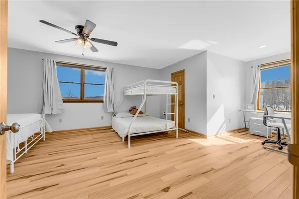 a bedroom with bed and a wooden floor