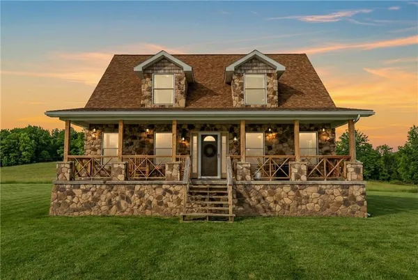 a view of a house with a big yard and large trees