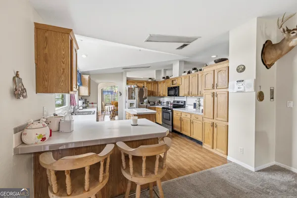 a kitchen that has a lot of cabinets in it and stainless steel appliances