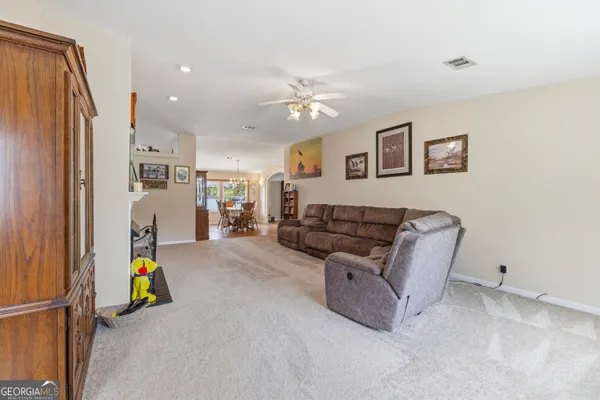 a living room with furniture and a refrigerator