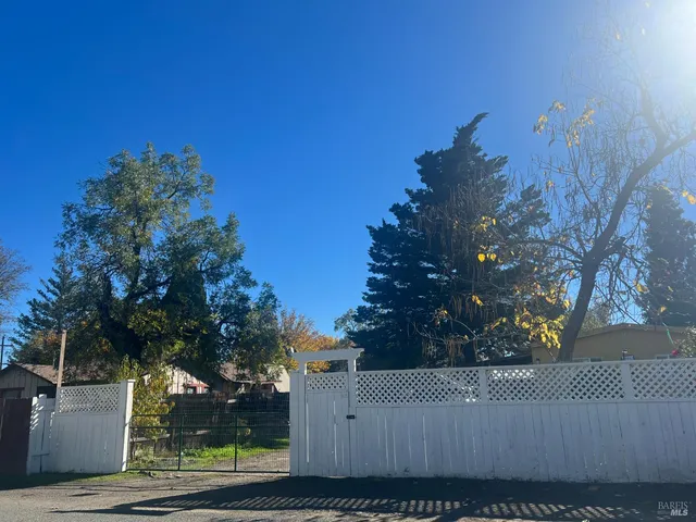 a view of a house with wooden fence next to a road