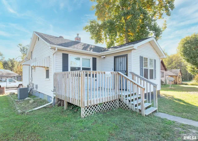 a view of a house with a yard and deck