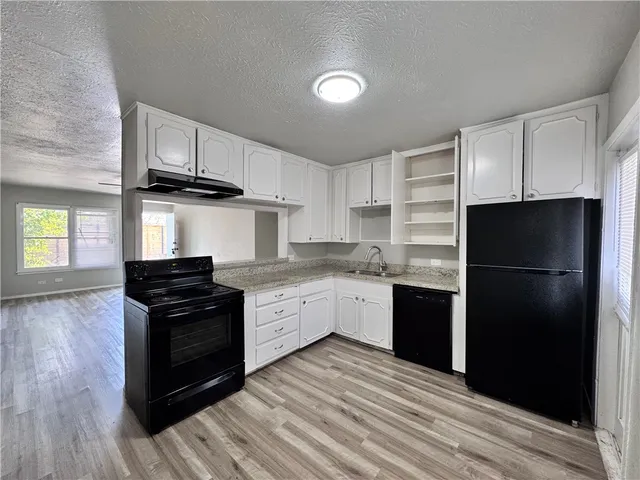 a kitchen with a refrigerator stove and wooden cabinets
