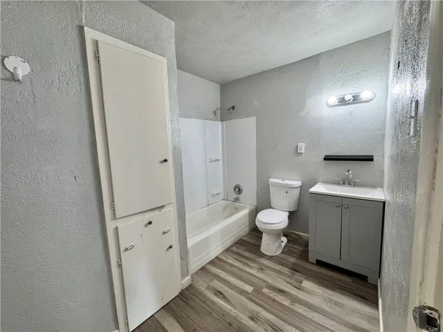 a bathroom with a granite countertop toilet a sink and a mirror