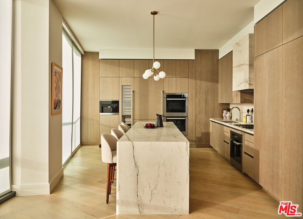 211 Elm Court, Unit 35B Los Angeles, CA 90067 - Photo 5 of 22 a kitchen with a refrigerator a stove and a sink with wooden floor