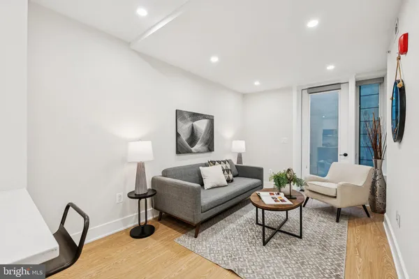 a living room with furniture a rug and a lamp