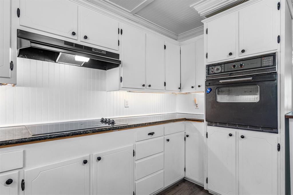 417 West 8th Street Justin, TX 76247 - Photo 13 of 40 a kitchen with white cabinets and appliances
